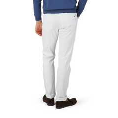 A man in White Super Stretch Michelangelo Jeans and a blue sweater by Tramarossa.