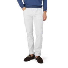 A man in Tramarossa's White Super Stretch Michelangelo Jeans and a blue sweater.