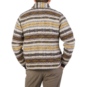The back view of a man wearing a Universal Works Brown Fair Isle Wool New York Button Cardigan with a striped pattern.