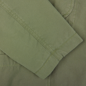 Close-up of a green Universal Works Birch Green Cotton Summer Canvas 5-Pocket Jacket with detailed stitching.