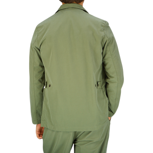 A man wearing a Universal Works Birch Green Cotton Summer Canvas 5-Pocket Jacket viewed from the back.