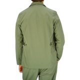 A man wearing a Universal Works Birch Green Cotton Summer Canvas 5-Pocket Jacket viewed from the back.