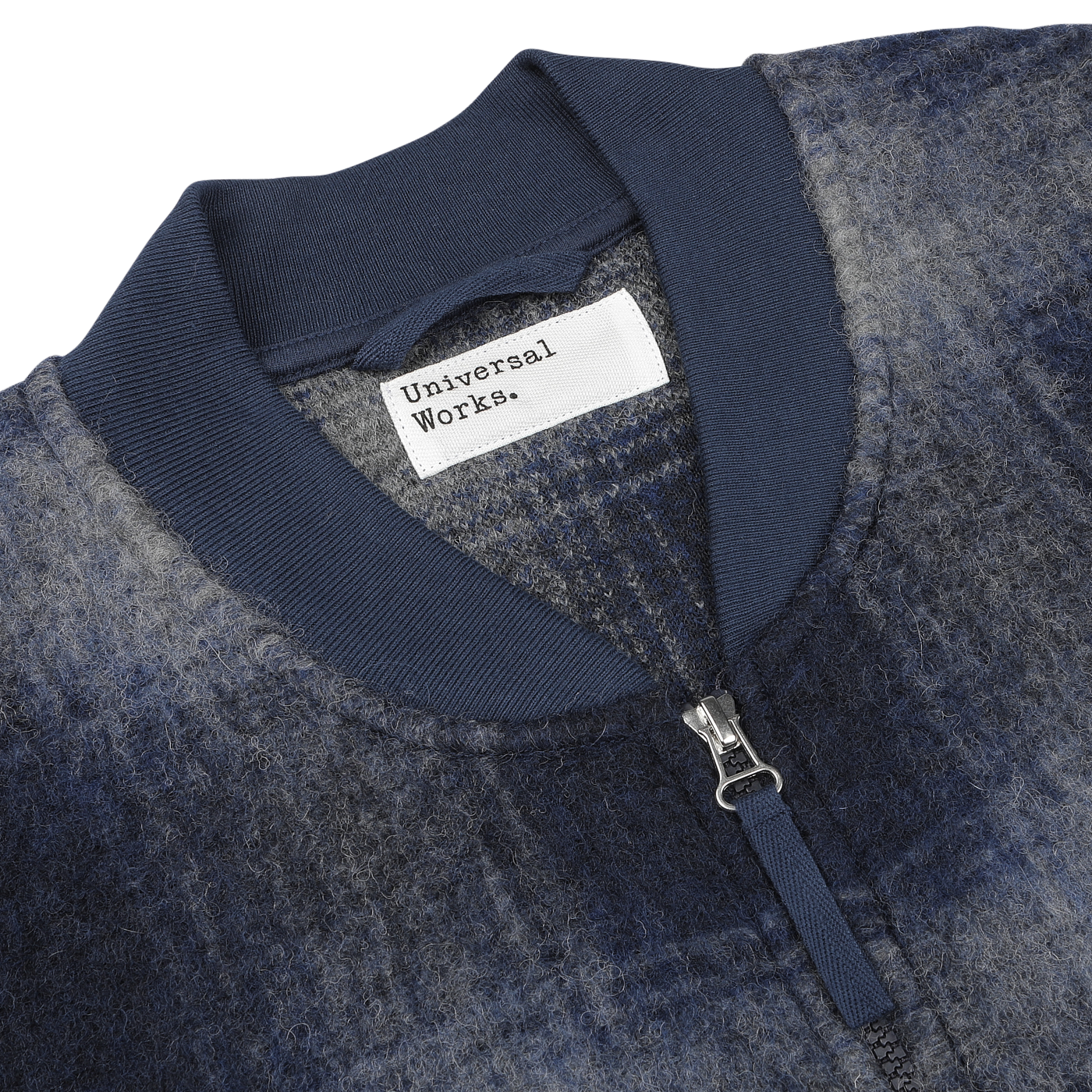 Close-up of a Blue-Grey Fresco Fleece Zip Waistcoat by Universal Works, showcasing its detailed label and sleek design.