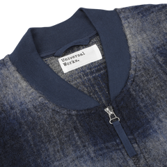 Close-up of a Blue-Grey Fresco Fleece Zip Waistcoat by Universal Works, showcasing its detailed label and sleek design.