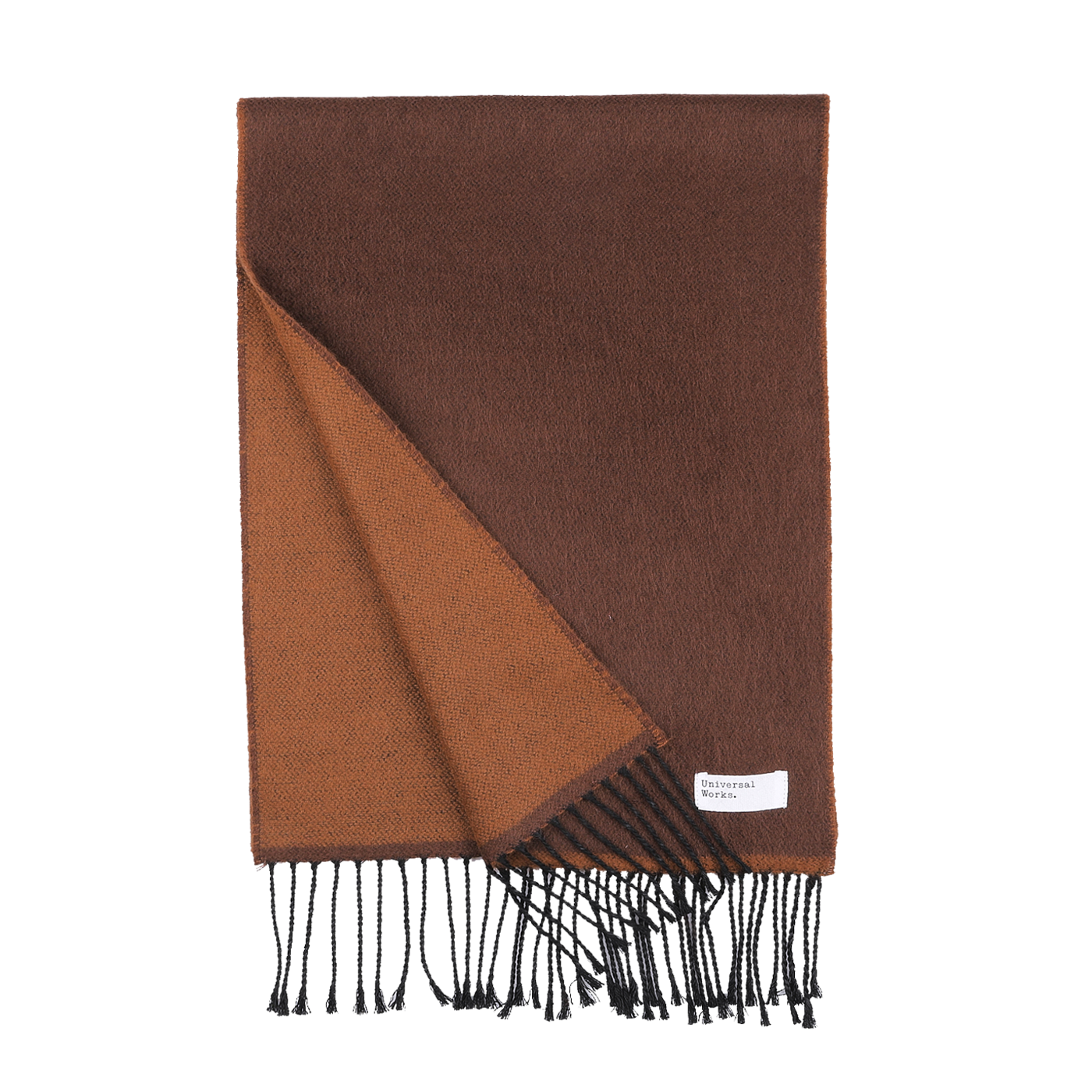 The Brown Double-Sided Acrylic Scarf by Universal Works showcases a meticulously folded design that reveals its rich brown hue and lighter brown underside, complete with fringed edges. A small label near the fringe subtly alludes to its premium acrylic fiber material, epitomizing the craftsmanship of Universal Works.