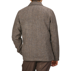 A person wearing a Brown Melange Harris Tweed Bakers C Jacket by Universal Works seen from the back.