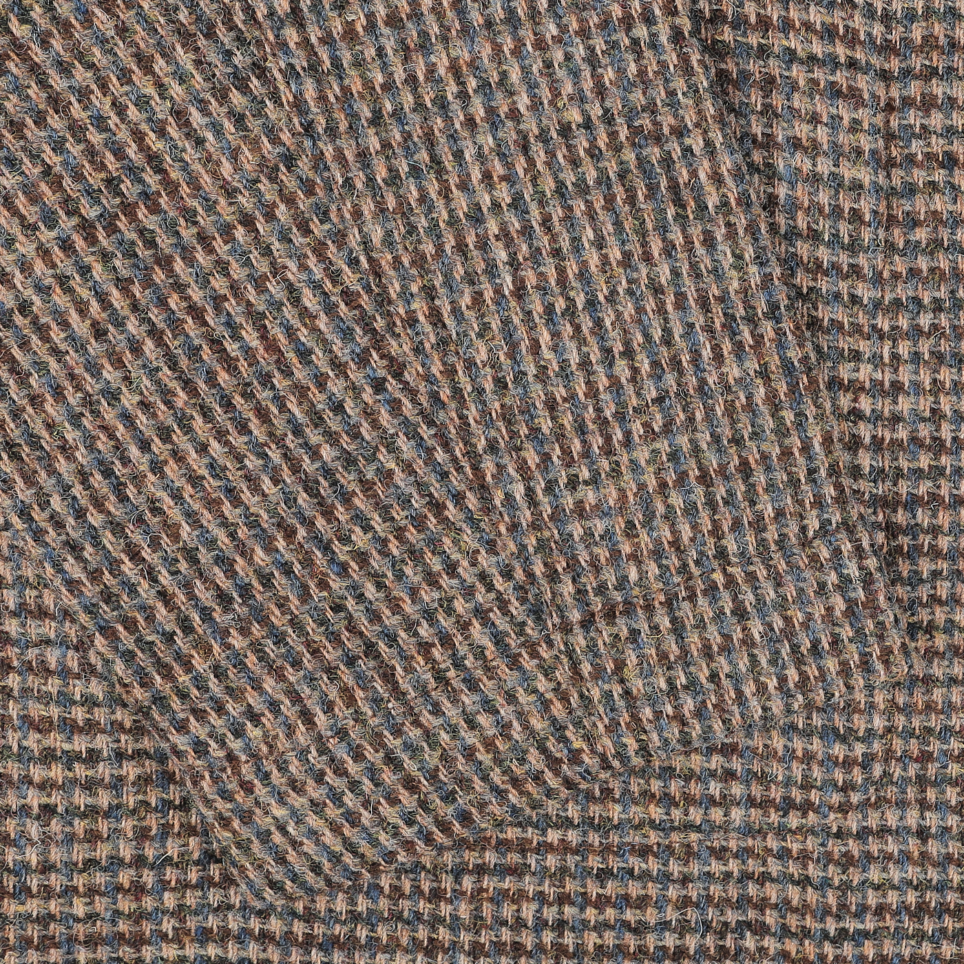 Close-up of the intricately detailed and textured woven fabric on the Brown Melange Harris Tweed Bakers C Jacket by Universal Works, showcasing multicolored threads with shades of brown and blue reminiscent of traditional Harris Tweed.