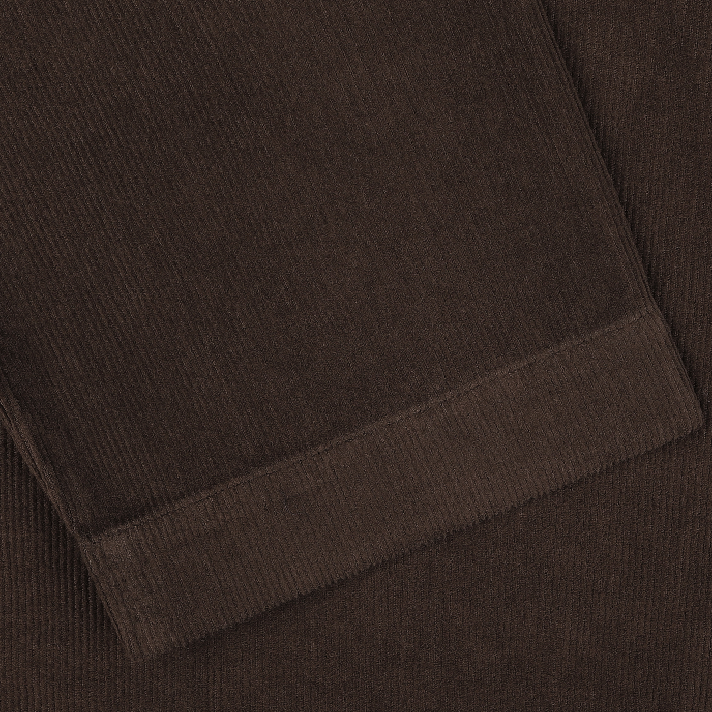 Close-up view of a folded Universal Works Dark Brown Fine Corduroy Bakers Overshirt, showcasing its visible texture and stitching, reminiscent of a classic shirt jacket.