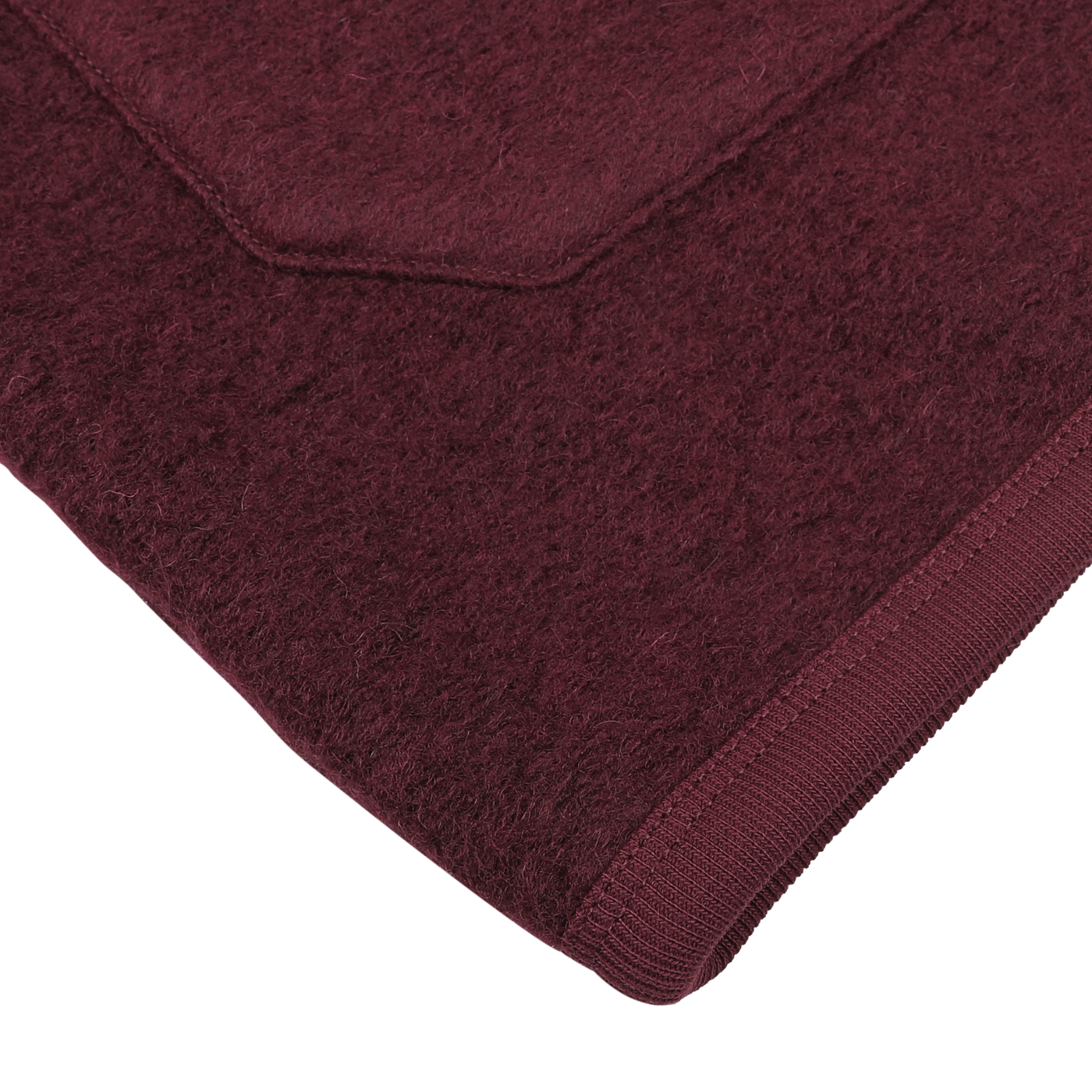 Close-up of the corner of a deep red wool fleece cardigan with a neatly sewn edge on a white background, reminiscent of the craftsmanship seen in Universal Works designs.