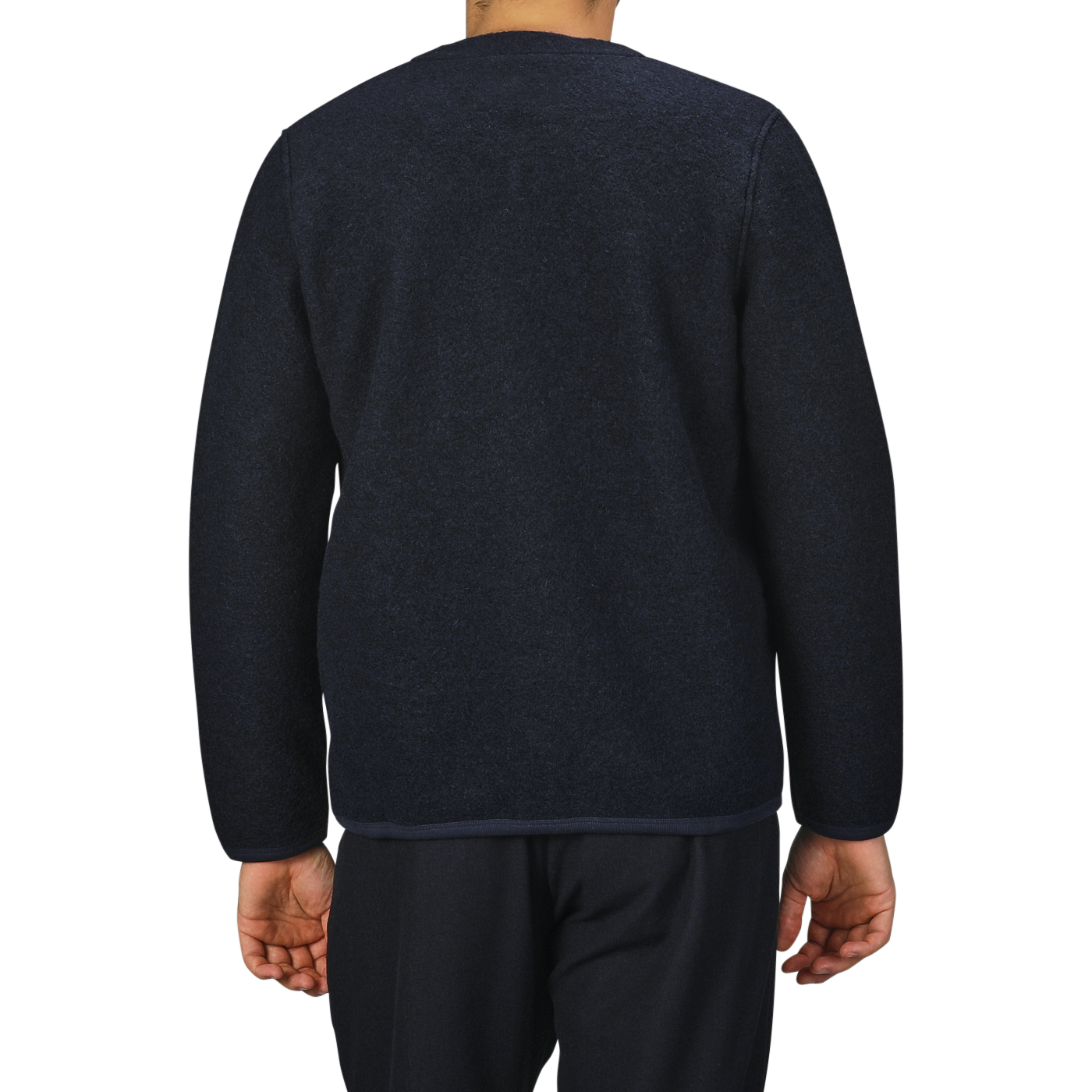 A person wearing a Navy Blue Wool Fleece Cardigan from Universal Works and navy blue pants stands with their back to the camera against a plain background, reminiscent of the brand's minimalist designs.