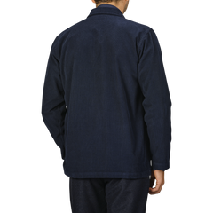 Man wearing a Universal Works Navy Fine Corduroy Bakers Overshirt and matching pants, seen from the back, standing against a plain background.