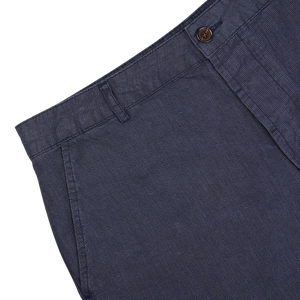 Close-up of Universal Works Navy Puppytooth Linen Mix Military Chinos with a front button visible.