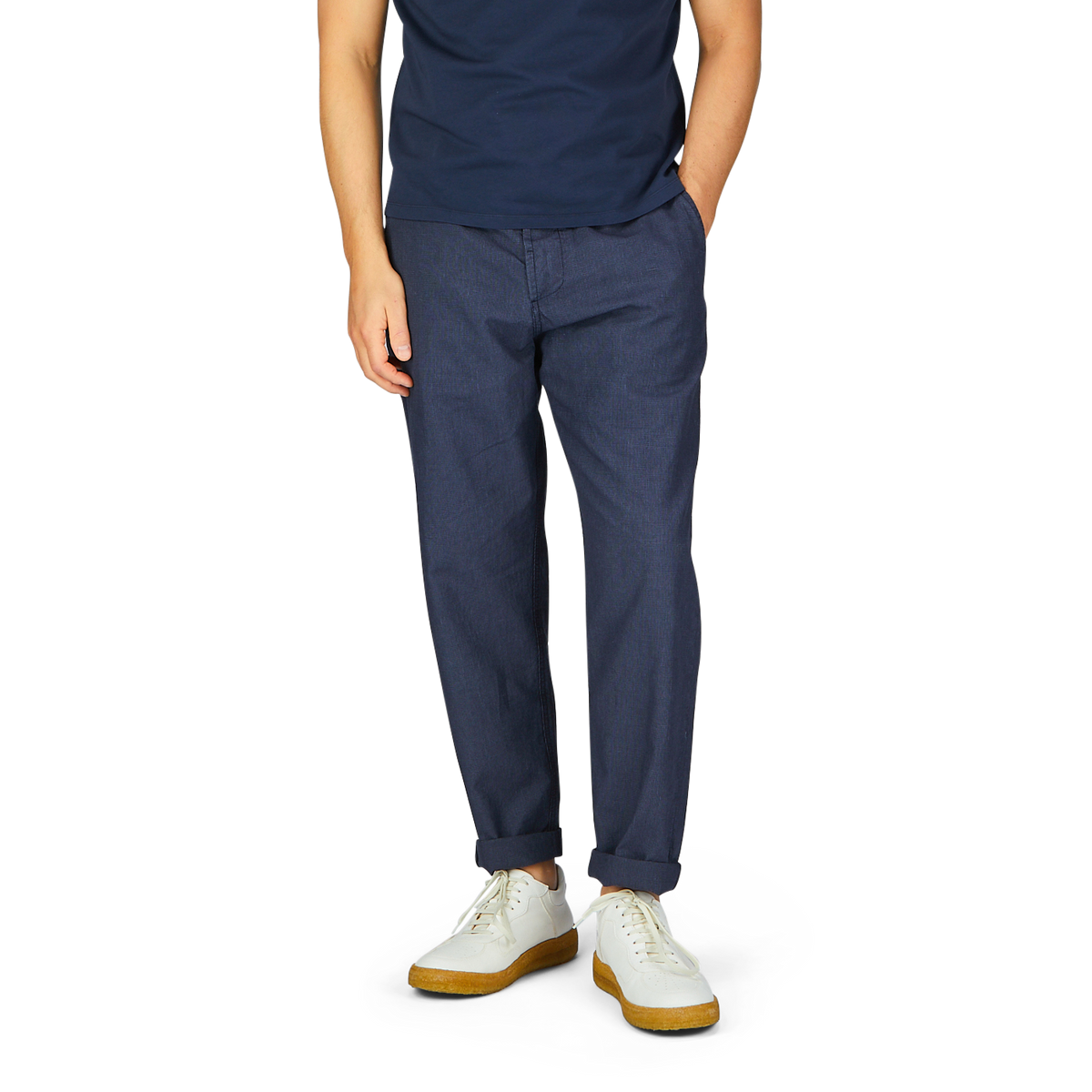 Man standing in Universal Works Navy Puppytooth Linen Mix Military Chinos and white shoes.