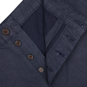 Close-up of a navy blue cotton suit jacket with buttons. could be replaced with Close-up of a Navy Puppytooth Linen Mix Military Chinos by Universal Works.