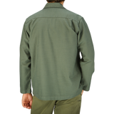 A man wearing a grey Universal Works Olive Green Cotton Sateen Dockside jacket seen from the back.