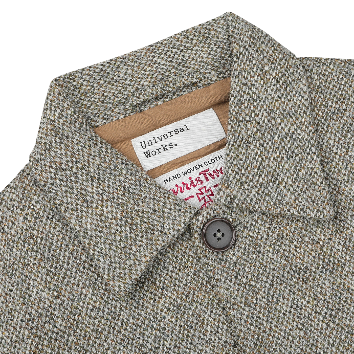 Close-up of a textured Olive Melange Harris Tweed Bakers C Jacket, showcasing labels that read "Universal Works" and "Harris Tweed." The neatly laid-out collar features a single button in clear view.