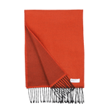 An orange double-sided acrylic scarf from Universal Works, featuring black fringe ends. A small white label with text is sewn onto one corner. Expertly made in Italy, this seasonal scarf ensures both quality and style.