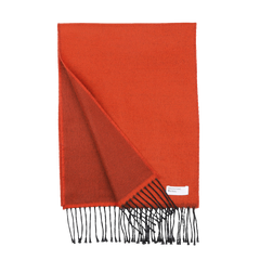 An orange double-sided acrylic scarf from Universal Works, featuring black fringe ends. A small white label with text is sewn onto one corner. Expertly made in Italy, this seasonal scarf ensures both quality and style.