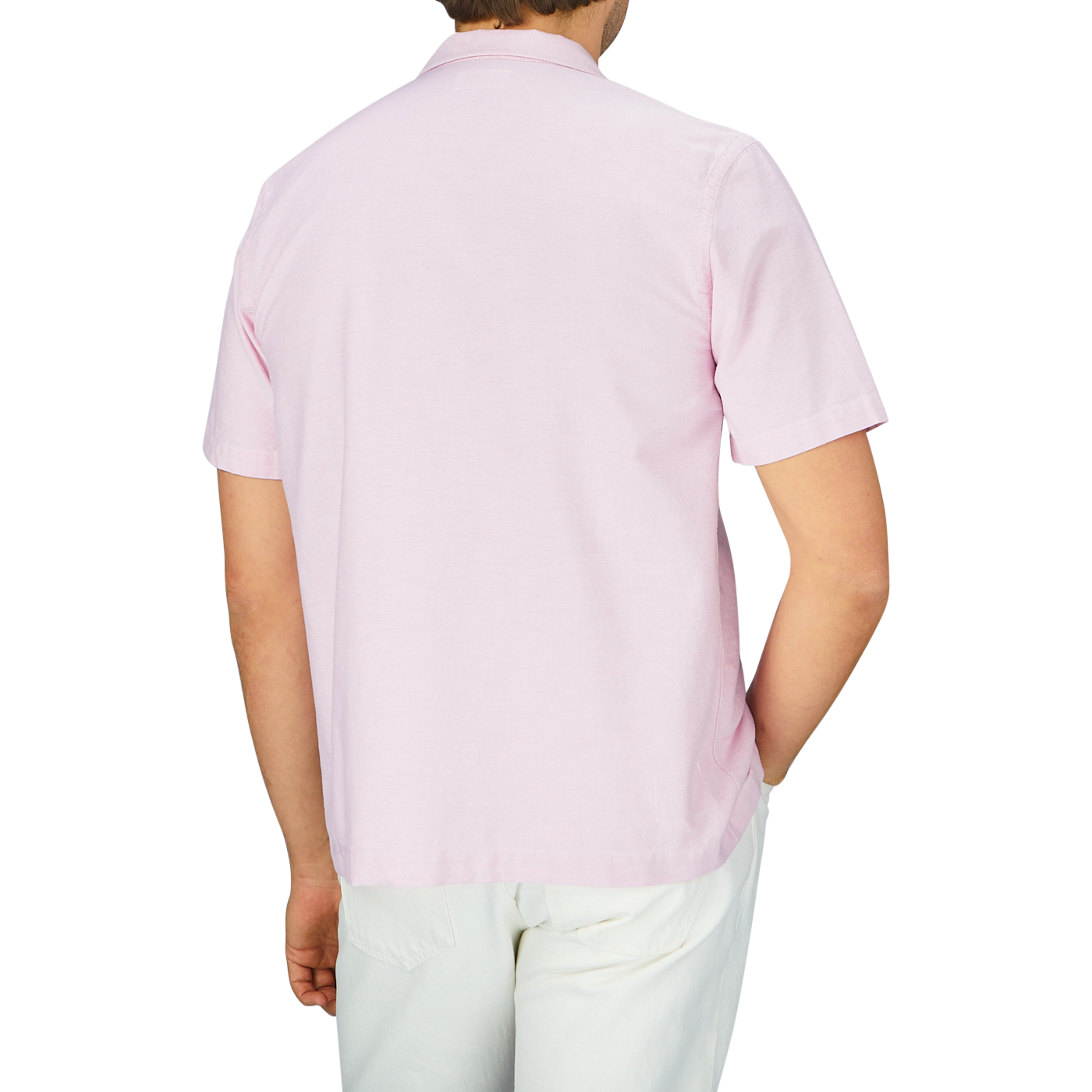 The back view of a man wearing a Universal Works Pink Cotton Oxford Camp Collar Road Shirt.