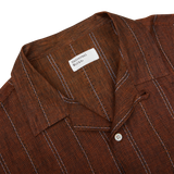 A Rust Brown Striped Linen Road Camp Collar Shirt with black and white stripes from Universal Works.