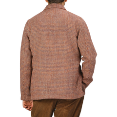 A person is shown from the back wearing a Rust Orange Harris Tweed Bakers C Jacket from Universal Works and matching brown pants.