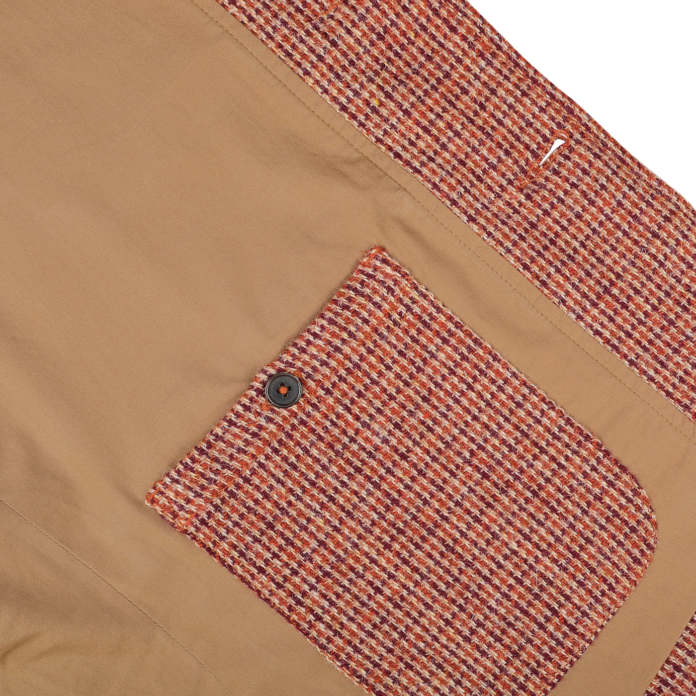 Close-up of a beige fabric with a textured red, white, and beige striped pattern on the pocket and trim, reminiscent of the Rust Orange Harris Tweed Bakers C Jacket by Universal Works, featuring a single dark button on the pocket.