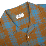 A brown and blue plaid, cotton camp collar shirt from Universal Works.