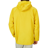 The back view of a man wearing a water-resistant Universal Works Yellow Cotton Ripstop Stanedge Jacket.
