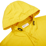 A yellow, water-resistant Yellow Cotton Ripstop Stanedge Jacket with a hood from Universal Works.