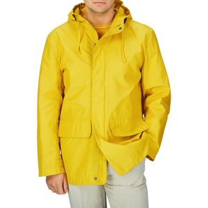 A man wearing a Universal Works Yellow Cotton Ripstop Stanedge Jacket.