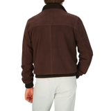 Rear view of a person wearing a Valstar Dark Brown Suede Leather Valstarino Jacket and white pants.