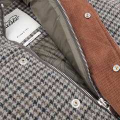 Close-up of a houndstooth-patterned gilet crafted from green houndstooth wool tweed, with a partially open zipper revealing a brown inner lining and a branded label showing "Valstar.