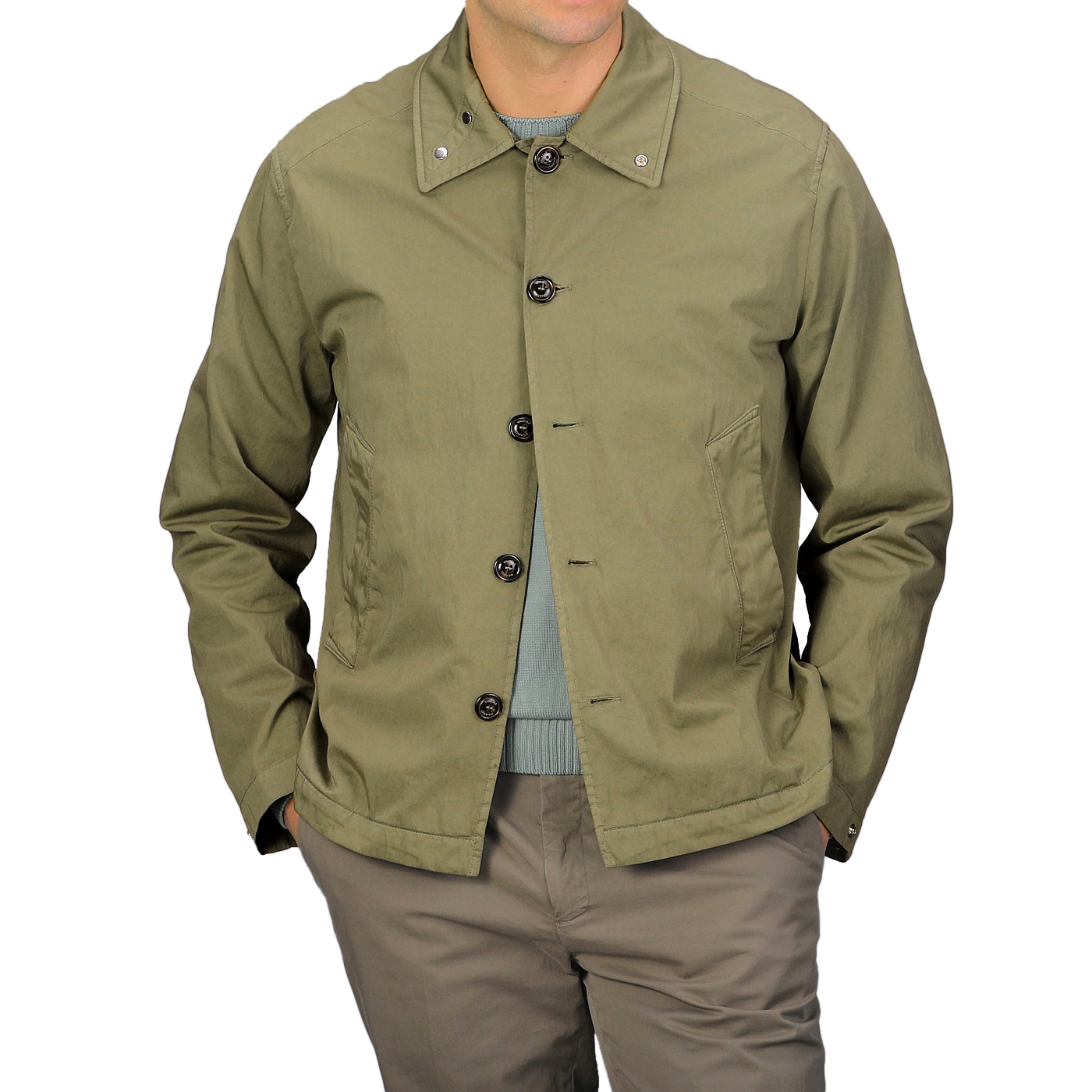 Someone dons a Valstar Green Soft Cotton Nylon Coach Jacket paired with a matching green shirt and khaki pants, standing against a gray backdrop.