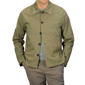 Someone dons a Valstar Green Soft Cotton Nylon Coach Jacket paired with a matching green shirt and khaki pants, standing against a gray backdrop.