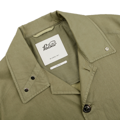 Close-up of a light green Valstar Green Soft Cotton Nylon Coach Jacket collar, highlighting metal buttons and a label with "Valstar Milano 1911," embodying a sportswear classic.