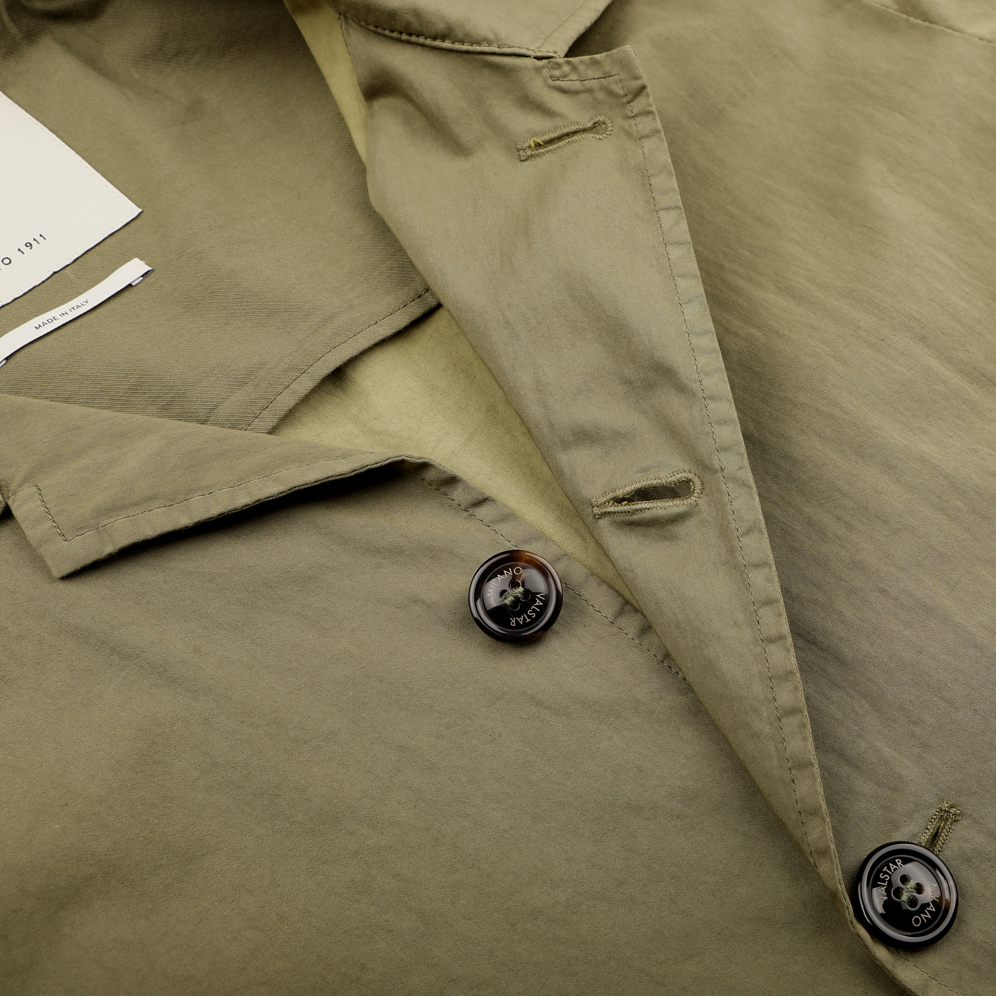 Close-up of Valstar's Green Soft Cotton Nylon Coach Jacket, showcasing buttons and stitching details along with a glimpse of the white label.