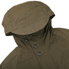 The Green Waxed Cotton Down Padded Archive Jacket from Valstar, artfully designed in a waxed cotton blend with three black buttons, is showcased laid flat on a white surface, highlighting the stylish essence of outerwear.