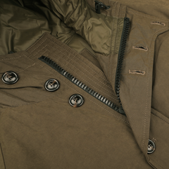 Close-up of the Valstar Archive Jacket, a stylish piece of outerwear crafted from a green waxed cotton blend, featuring a zipper and several buttons on its fabric.