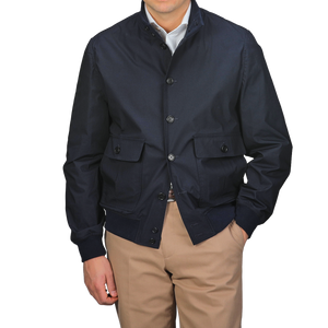 Standing against a gray background, a person wears the Valstar Navy Blue Cotton Poplin Valstarino Jacket over a white shirt and beige pants.