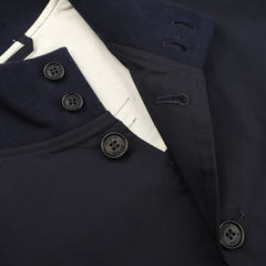 Close-up of the Navy Blue Cotton Poplin Valstarino Jacket collar by Valstar, featuring black buttons on a white lining. The collar, reminiscent of classic design, has buttonholes and a partially visible tag.