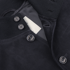 Close-up of a navy blue suede leather jacket by Valstar, featuring a ribbed collar, buttons, and visible inner tag, echoing the iconic Valstarino style.