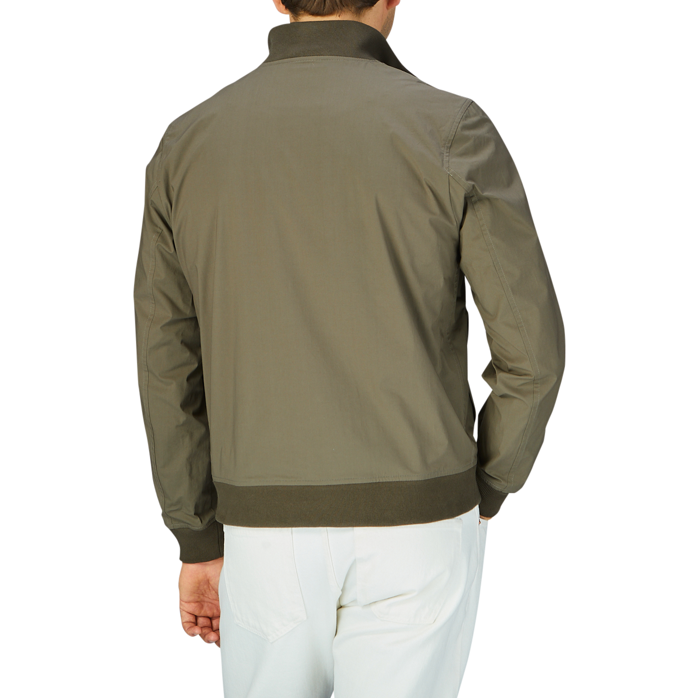 Man wearing an olive green cotton ripstop Valstar jacket with a ribbed collar and white trousers, viewed from the back.