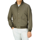 Man wearing an Olive Green Cotton Ripstop Valstarino Jacket with flap pockets and white trousers.