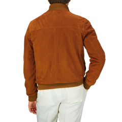 Man wearing an Italian Sandal Brown Suede Leather Valstarino jacket and white pants, seen from the back.