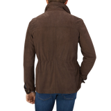 The back view of a man wearing a Dark Brown Suede Anton Leather Jacket, crafted with expertise by Werner Christ, a leather specialist.