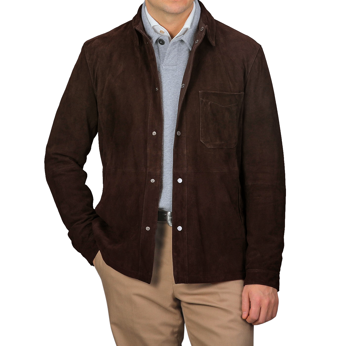 A person stands against a plain gray background, wearing the Dark Brown Suede Leather Amaro Shirt Jacket by Werner Christ over a light gray top and khaki pants, with one hand in their pocket.