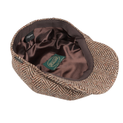 The Beige Magee Herringbone Wool Tweed Newsboy Classic Cap by Wigéns is pictured from above, showcasing its dark brown satin lining with a green label inside.