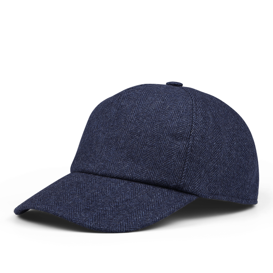 The Wigéns Blue Herringbone Angelico Wool Baseball Cap boasts a dark blue herringbone pattern and features an adjustable strap, curved brim, and a button on top. The luxurious wool is expertly woven in Italy.