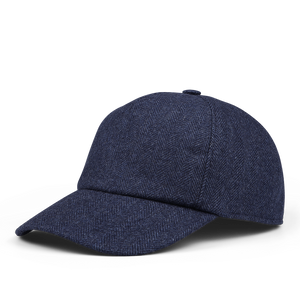 The Wigéns Blue Herringbone Angelico Wool Baseball Cap boasts a dark blue herringbone pattern and features an adjustable strap, curved brim, and a button on top. The luxurious wool is expertly woven in Italy.