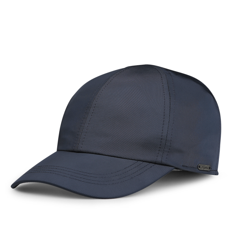 The Blue Nylon Fleece Lined Baseball Cap by Wigéns is made from technical nylon, showcasing a dark blue hue with a curved brim and a textured seam design.